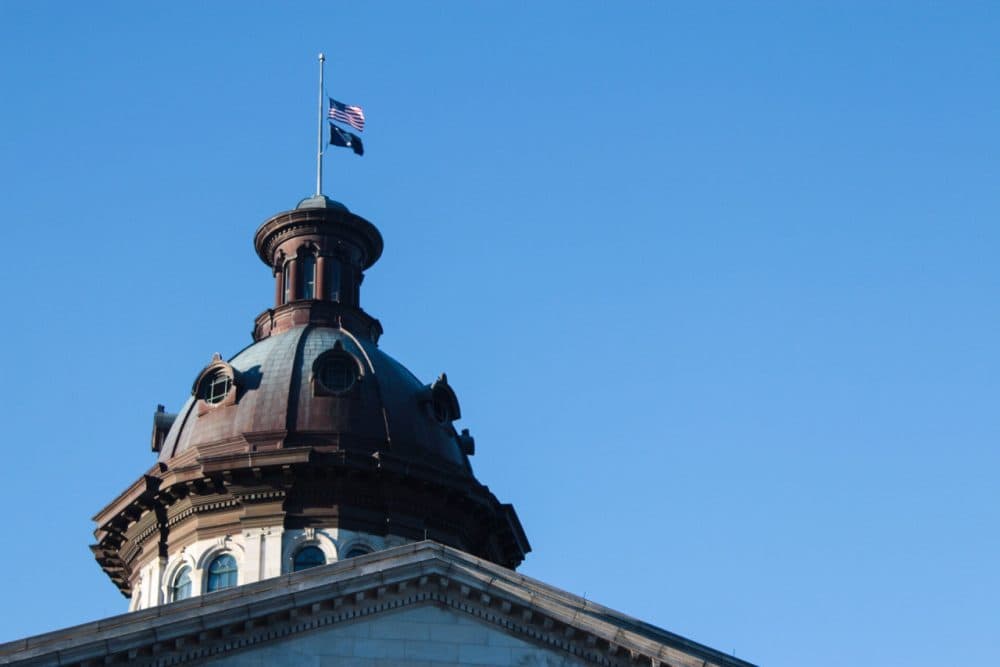 Atop the South Carolina State House in Columbia, the flags fly at half-staff in honor of the late Justice Antonin Scalia. (Dean Russell/Here &amp; Now)