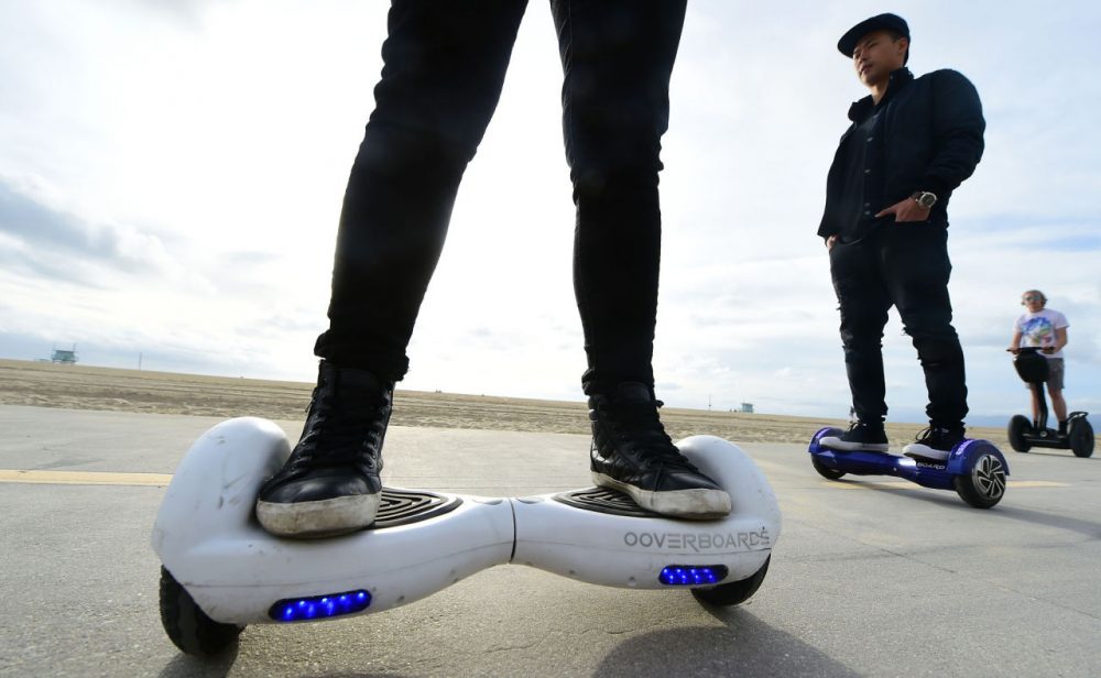 People ride their hoverboards on the Venice Beach Boardwalk, California on December 10, 2015. These so-called hoverboards, or self-balancing electric scooters, are surging in popularity in the first season where they have been available at relatively affordable prices -- as low as $300 for some models. (Frederic J. Brown/AFP/Getty Images)