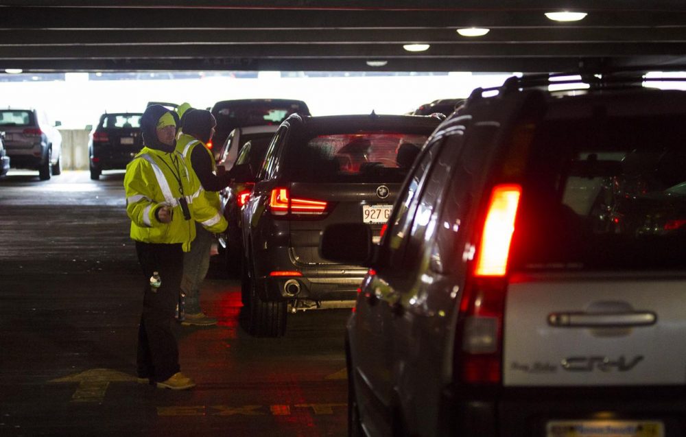 Central Parking Garage attendants guide and register customers as they box in other cars already parked in assigned parking spots. The cars will be left where they are stopped until cars parked in assigned spots leave. (Jesse Costa/WBUR)