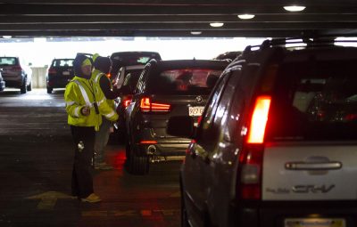 Central Parking Garage attendants guide and register customers as they box in other cars already parked in assigned parking spots. The cars will be left where they are stopped until cars parked in assigned spots leave. (Jesse Costa/WBUR)