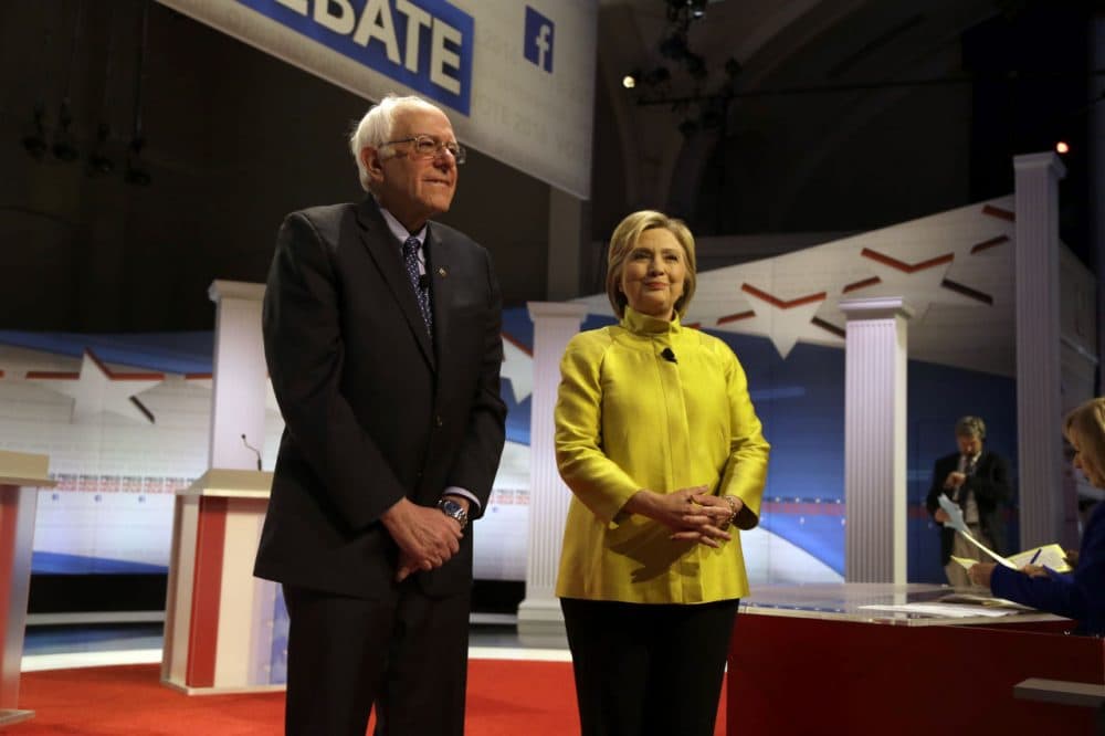 A WBUR poll finds Hillary Clinton leads her presidential primary rival, Bernie Sanders, among likely Democratic voters in Massachusetts. Here, Sanders and Clinton are seen before a Feb. 11 debate in Milwaukee. (Tom Lynn/AP)