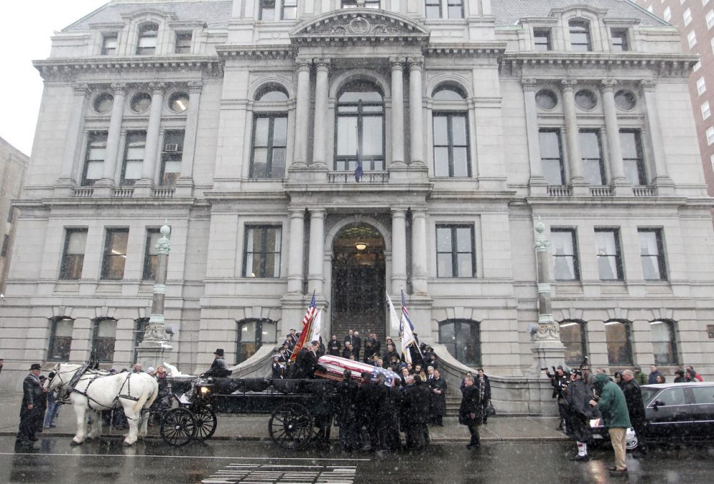 Pallbearers carry the casket of former Providence Mayor Buddy Cianci out of Providence's City Hall and onto a horse drawn carriage headed for Cathedral of Saints Peter and Paul for Cianci's funeral on Monday. Cianci died Jan. 28 at age 74. He served 21 years in office and was the city’s longest-serving mayor. (Stew Milne/AP)
