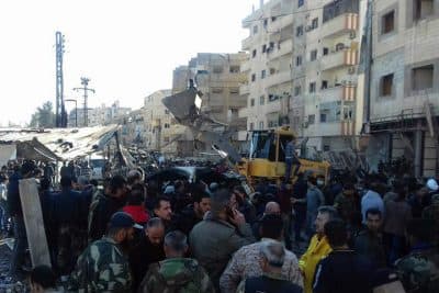 In this photo released by the Syrian official news agency SANA, Syrians gather where three bombs exploded in Sayyda Zeinab, a predominantly Shiite Muslim suburb of the Syrian capital, Syria, Sunday, Jan. 31, 2016. The triple bombing claimed by the extremist Islamic State group killed at least 45 people near the Syrian capital of Damascus on Sunday, overshadowing an already shaky start to what are meant to be indirect Syria peace talks. (SANA via AP)