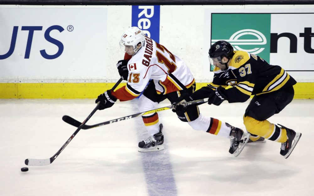 Flames left wing Johnny Gaudreau controls the puck as Bruins center Patrice Bergeron chases him in the third period, Tuesday, March 1, 2016, in Boston. (Elise Amendola/AP)