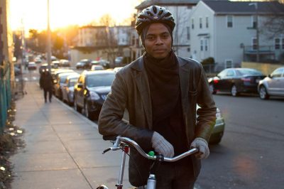 Noah Hicks stands with his bike outside Bowdoin Bike School on Southern Ave in Dorchester. (Hadley Green for WBUR)