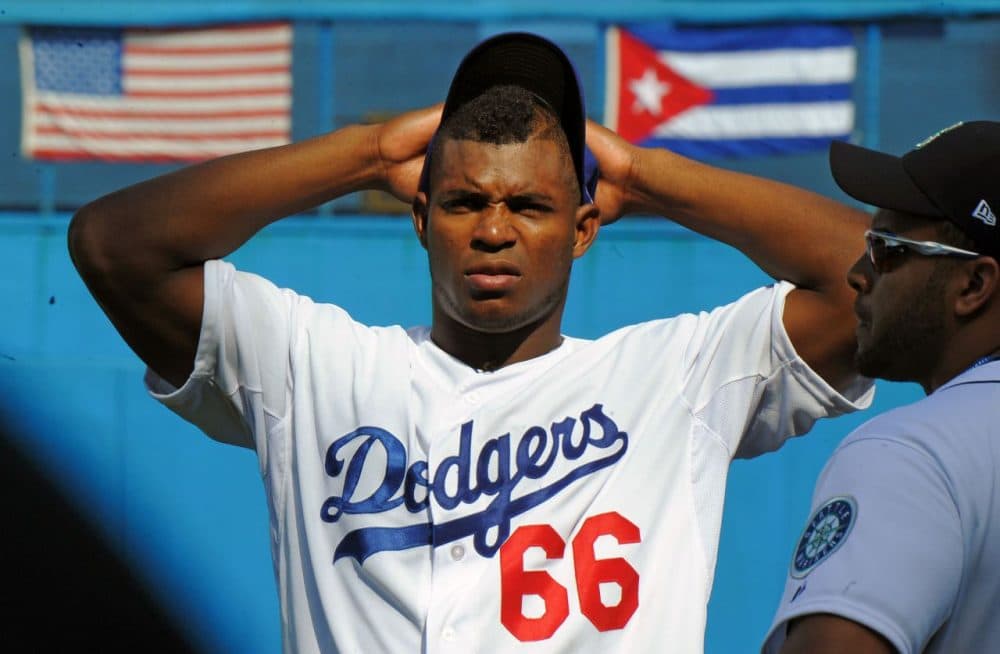 Cuban MLB player Yasiel Puig is pictured during a children's baseball training session at the Latin American Stadium in Havana, on December 16, 2015. Cuban baseball stars Jose Abreu and Yasiel Puig returned home for the first time since defecting to join the American big leagues, part of an unprecedented Major League Baseball tour made possible by the thaw in U.S.-Cuban relations. The delegation also includes Cuban-born player Alexei Ramirez, a free agent who left Cuba legally by marrying a Dominican in 2007. (Yamil Lage/AFP/Getty Images)