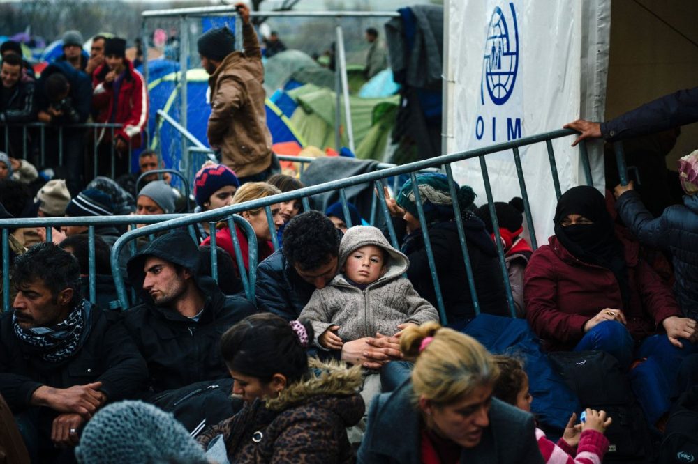 Refugees and migrants sit beside the gate at the Greek-Macedonian border near the Greek village of Idomeni, on March 7, 2016, where thousands of refugees and migrants wait to cross the border into Macedonia.
EU leaders held a summit with Turkey's prime minister on March 7 in order to back closing the Balkans migrant route and urge Ankara to accept deportations of large numbers of economic migrants from overstretched Greece. (Dimitar Dilkoff/AFP/Getty Images)