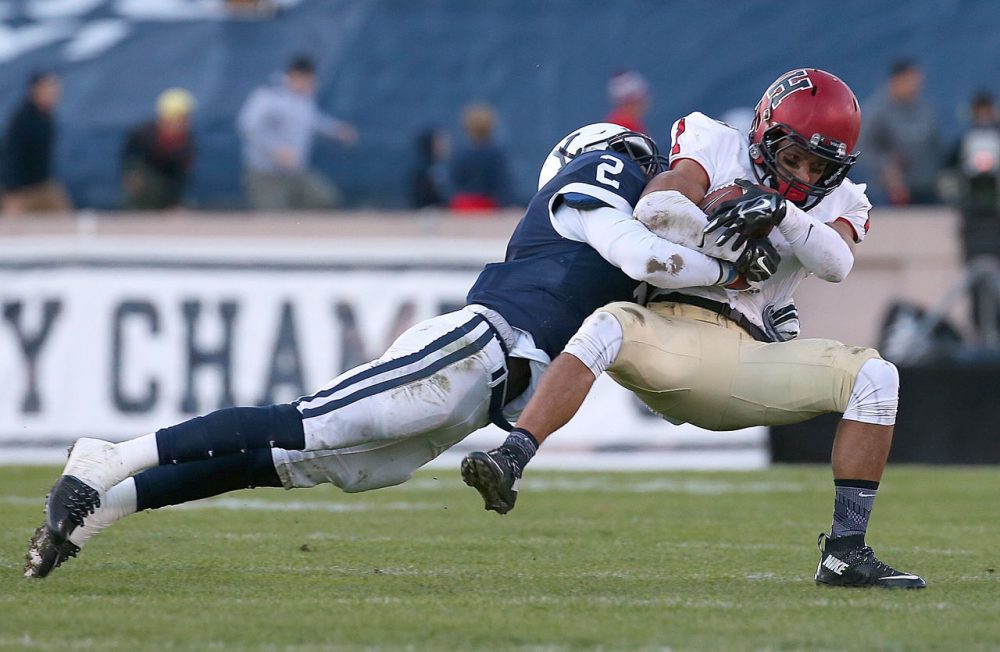 Andrew Fischer #1 of the Harvard Crimson gains yards against the defense of Marquise Peggs #2 of the Yale Bulldogs in the first half on November 21, 2015 in New Haven, Connecticut. (Jim Rogash/Getty Images)