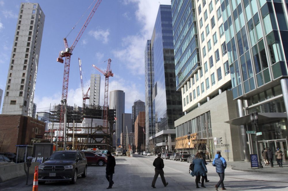 Construction takes place on two buildings, left, adjacent to three recently built buildings, right, in Boston's Seaport District. (Bill Sikes/AP)