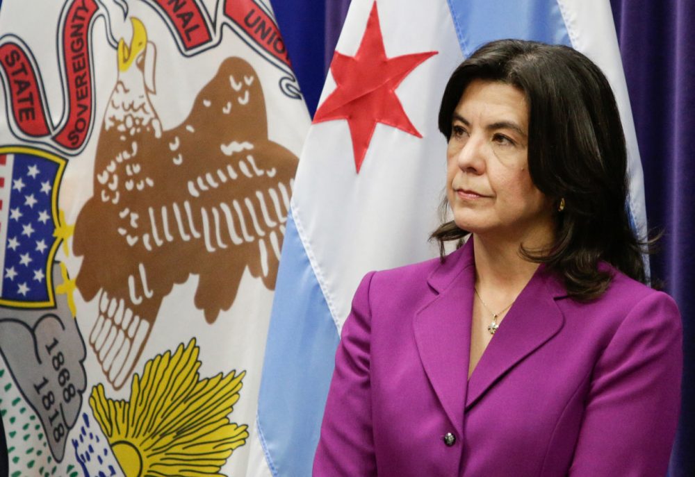 Cook County State's Attorney Anita Alvarez listens as Interim Chicago Police Superintendent John Escalante speaks at a news conference Tuesday, March 8, 2016, in Chicago. Escalante said a Chicago man has been charged with first-degree murder, after police say he helped lure a 9-year-old boy into an alley with a juice box late last year and then shot him in the head because of his father's gang ties. Dwright Boone-Doty was charged Monday night in the Nov. 2 death of Tyshawn Lee. Alvarez said Boone-Doty shot the boy several times at close range. (AP Photo/Teresa Crawford)