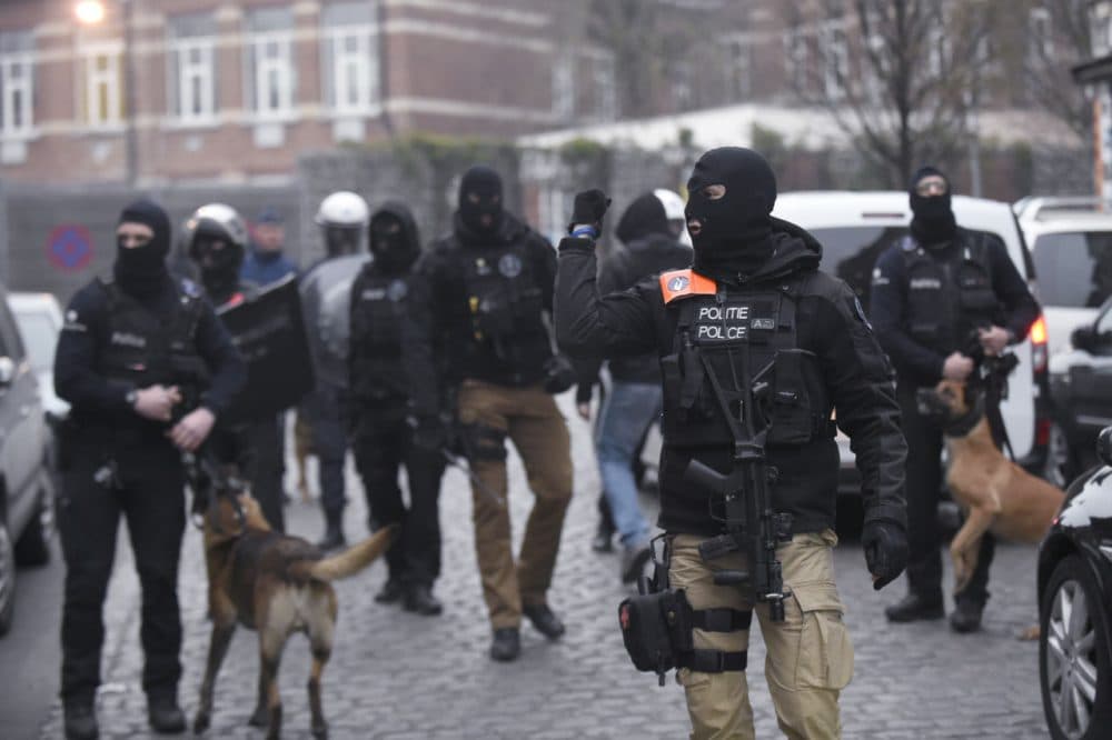 Belgian policemen walk in a street during a police action in the Molenbeek-Saint-Jean district in Brussels, on March 18, 2016. (John Thys/AFP/Getty Images)