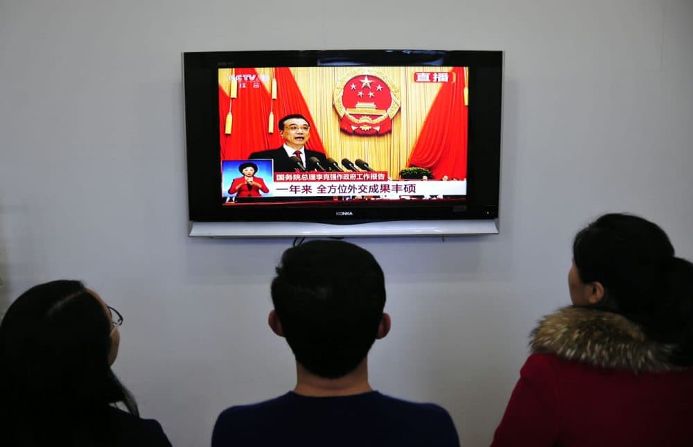 Chinese people watch live television coverage at a conference room in Yantai, east China's Shandong province as Chinese Premier Li Keqiang delivers his report during the opening ceremony of the National People's Congress in the Great Hall of the People in Beijing on March 5, 2016. (STR/AFP/Getty Images)