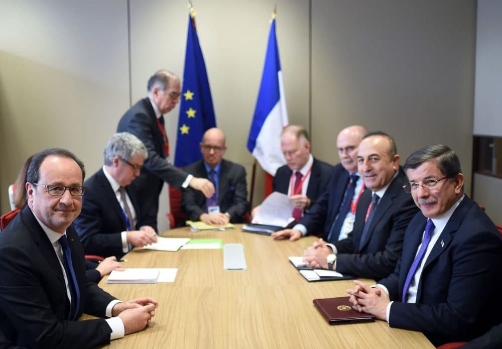 French President Francois Hollande (left) meets with Turkish Prime Minister Ahmet Davutoglu (right) and Foreign Minister Mevlut Cavusoglu (second from right) on the second day of a European Union summit to discuss the ongoing migrant crisis, in Brussels, on March 18, 2016. (Stephanie de Sakutin/AFP/Getty Images)