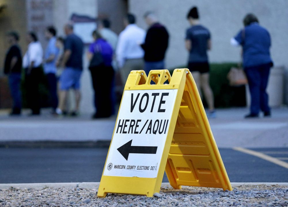 Voters wait in line at dawn to cast their ballot in Arizona's presidential primary election Tuesday in Phoenix. (Matt York/AP)
