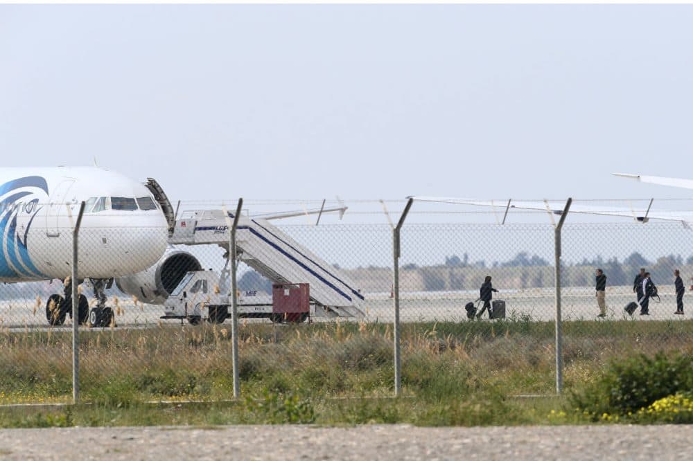 Passengers, or crew members, leave the hijacked aircraft of Egyptair at Larnaca Airport on Tuesday. (Petros Karadjias/AP)