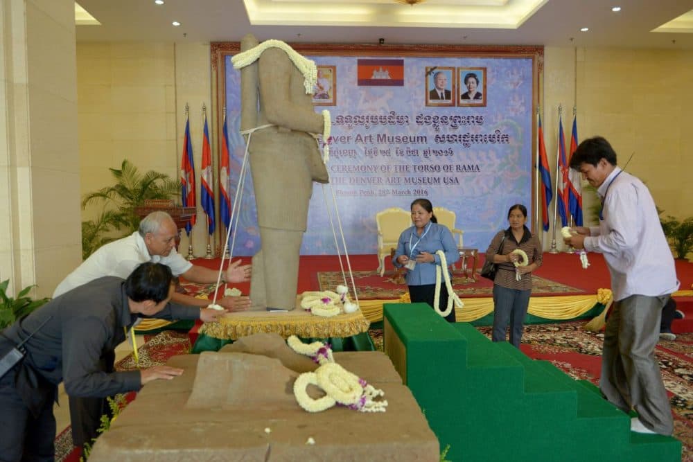 Cambodians gather around a 10th-century sandstone sculpture of the Hindu god Rama after it was returned from the Denver Art Museum during a ceremony at the Council of Ministers in Phnom Penh on March 28, 2016. The 62-inch-tall torso, which was stolen in the 1970s from the Koh Ker temple site near the famed Angkor Wat complex, was handed over by the museum, which had possession since 1986. (Tang Chhin Sothy/AFP/Getty Images)