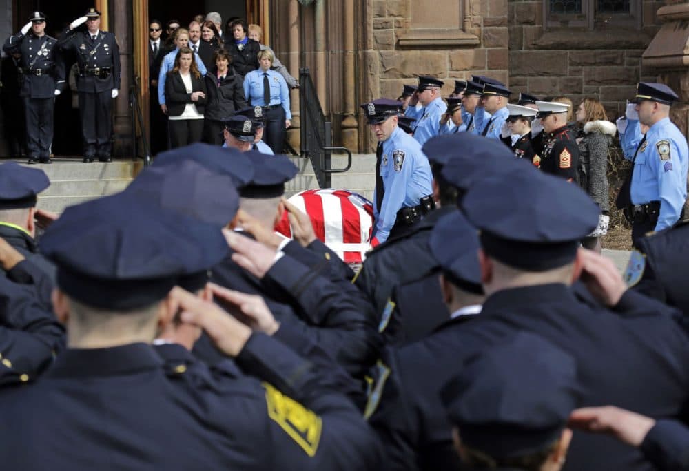 Police salute the casket of Prince William County, Va., Police Officer Ashley Guindon, as pallbearers exit Sacred Heart Church, Monday, in Springfield, Mass. Guindon, 28, a Springfield native, was killed during her first shift on the job Feb. 27 while responding to a domestic dispute in Woodbridge, Va. (Elise Amendola/AP)