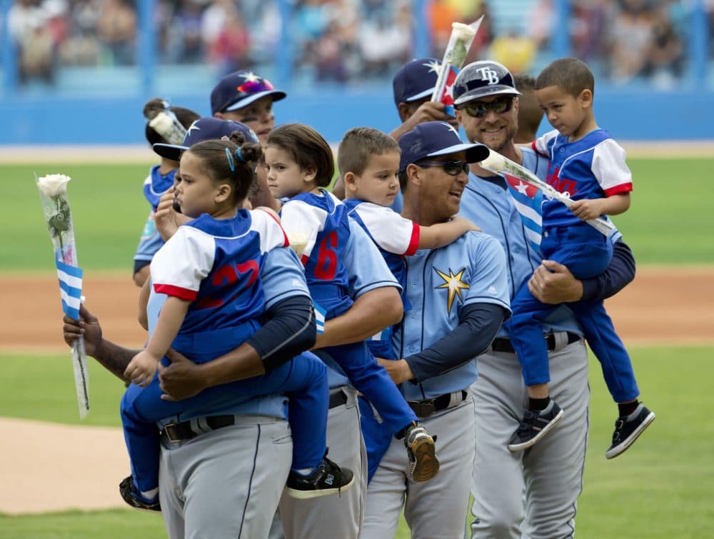 Members of the Tampa Bay Rays carry local Cuban children during opening ceremonies prior the start of an exhibition baseball game against the Cuban National team at the Estadio Latinoamericano, Tuesday, March 22, 2016, in Havana, Cuba. President Barack Obama and Cuban President Raul Castro also attended the exhibition game. (AP Photo/Pablo Martinez Monsivais)