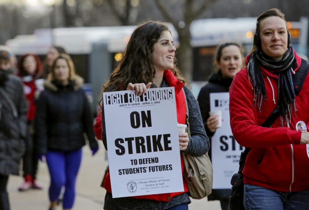 Colleen McDonough, a first-grade teacher at Walt Disney Magnet School in Chicago holds a picket sign outside the school, Friday, April 1, 2016,  during a one-day strike by Chicago teachers and supporters aimed at halting education funding cuts. (Teresa Crawford/AP)