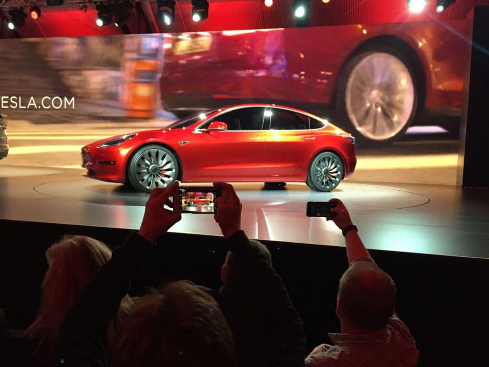 Tesla Motors unveils the new lower-priced Model 3 sedan at the Tesla Motors design studio Thursday, March 31, 2016, in Hawthorne, Calif. It doesn't go on sale until late 2017, but in the first 24 hours that order banks were open, Tesla said it had more than 115,000 reservations. Long lines at Tesla stores, reminiscent of the crowds at Apple stores for early models of the iPhone, were reported from Hong Kong to Austin, Texas, to Washington, D.C. Buyers put down a $1,000 deposit to reserve the car.  (AP Photo/Justin Prichard)