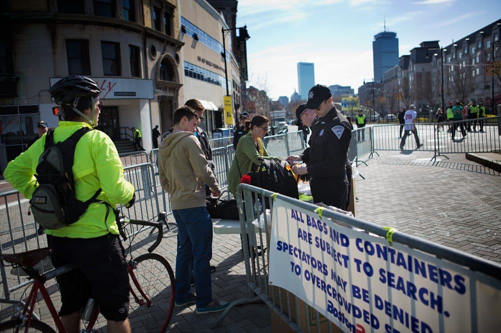 In this file photo from the 2014 Boston Marathon, Boston Police check bags along the marathon route near Kenmore Square. (Jesse Costa/WBUR)