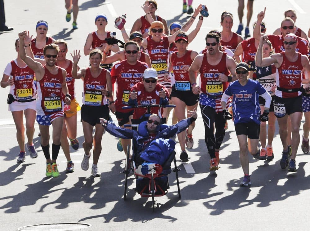 Dick Hoyt and Rick Hoyt cross the finish line surrounded by supporters in the 118th Boston Marathon in Boston April 2014. (Charles Krupa/AP)