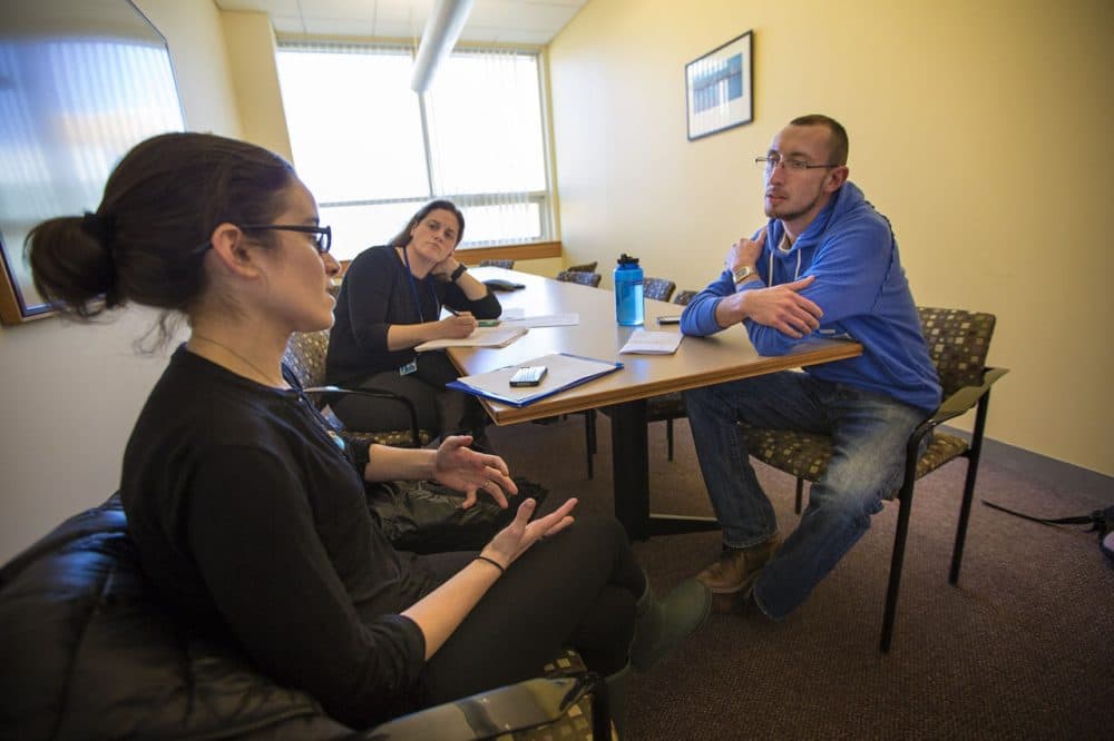 Justin Marotta, right, takes his oral mid-term exam for a suicide prevention course at the Simmons College School of Social Work. Laura Goodman, left, is role-playing as the client, as course instructor Kim O'Brien observes. (Jesse Costa/WBUR)