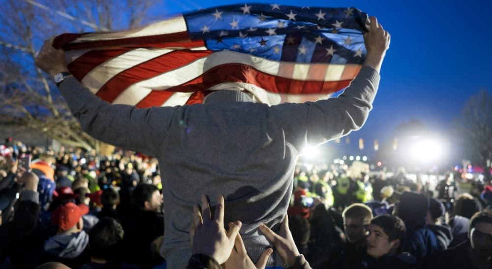 A Donald Trump supporter is hoisted up holding an American flag as the group faced off with Trump protesters, near the site of a campaign appearance by the Republican presidential candidate in Bethpage, N.Y., Wednesday, April 6, 2016. (Craig Ruttle/AP)