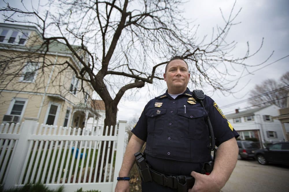Watertown Police Officer John MacLellan stands in front of a tree on Laurel Street, which he and other police officers stood behind during the armed standoff with the Tsarnaevs in 2013. Four bullets were found in the trunk of the tree after the shootout. (Jesse Costa/WBUR)