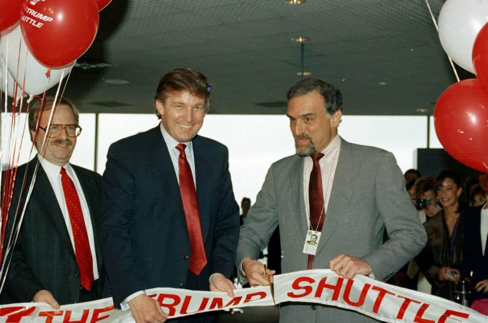Donald Trump, second from left, holds a ribbon at Logan International Airport in Boston, as Massport deputy-executive director Patrick Moscaritolo cuts it to officially open the Trump Shuttle airline terminal on June 8, 1989. (Elise Amendola/AP)