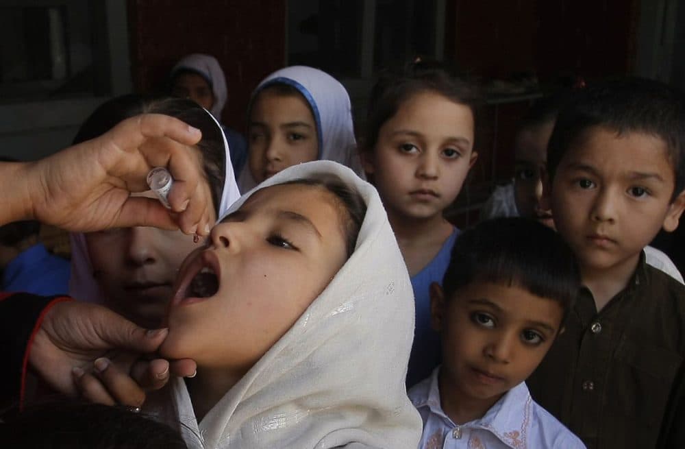 A Pakistani health worker gives an oral polio vaccine to a student at a school in Peshawar, Pakistan.(Mohammad Sajjad/AP)