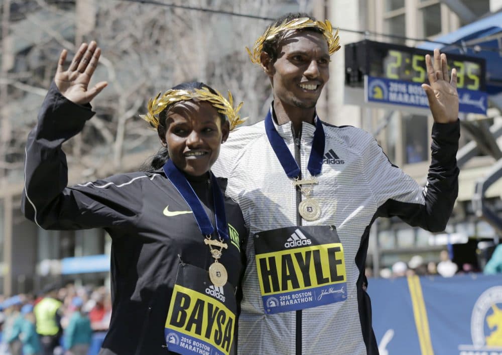 Atsede Baysa, left, and Lemi Berhanu Hayle, both of Ethiopia, pose for photos after winning the women's and men's races of the Boston Marathon on Monday. (Elise Amendola/AP)