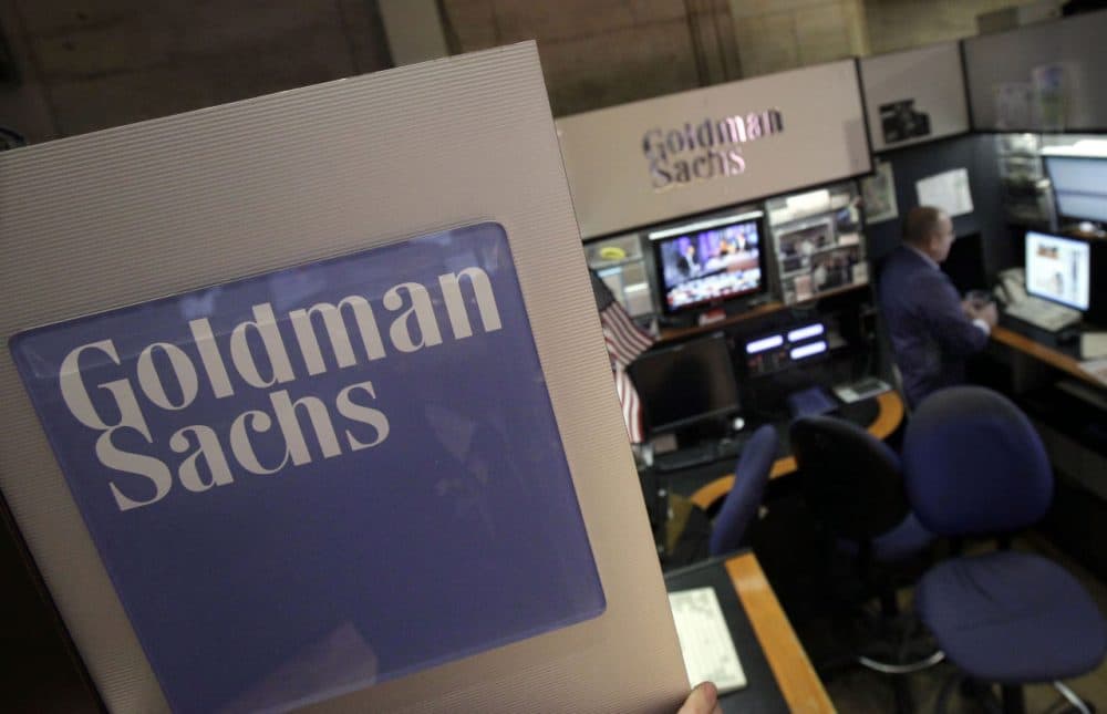 In this March 15, 2012 photo, a trader works in the Goldman Sachs booth on the floor of the New York Stock Exchange.  Goldman Sachs reached a $5 billion settlement as part of a federal and state probe into its role in the sale of mortgages in the years leading up into the housing bubble and subsequent financial crisis. (Richard Drew/AP)