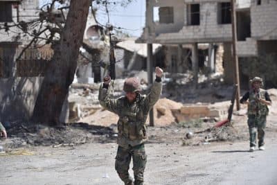 Syrian soldiers celebrate their victory against the Islamic State group in Qaryatain, Syria, Monday, April 4, 2016. (AP Photo/Natalia Sancha