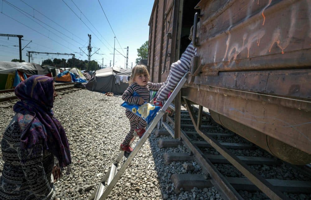 A woman watches over her daughters as they go up a ladder into a cargo train at a makeshift camp for migrants and refugees at the Greek-Macedonian border near the village of Idomeni on April 27, 2016.
Some 54,000 people, many of them fleeing the war in Syria, have been stranded on Greek territory since the closure of the migrant route through the Balkans in February. (Joe Klamar/AFP/Getty Images)