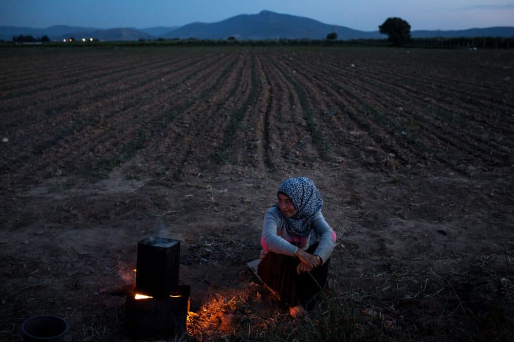 A Syrian refugee woman waits for water to boil outside her home at a tent camp on the outskirts of Izmir on April 28, 2016 in Izmir, Turkey.  (Chris McGrath/Getty Images)