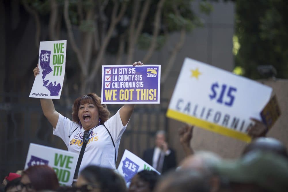 Service Employees International Union members celebrate after California Governor Jerry Brown signed landmark legislation SB 3 into law on April 4, 2016 in Los Angeles, California. The law makes California the first state in the nation to commit to raising the minimum wage to $15 per hour statewide. (David McNew/Getty Images)