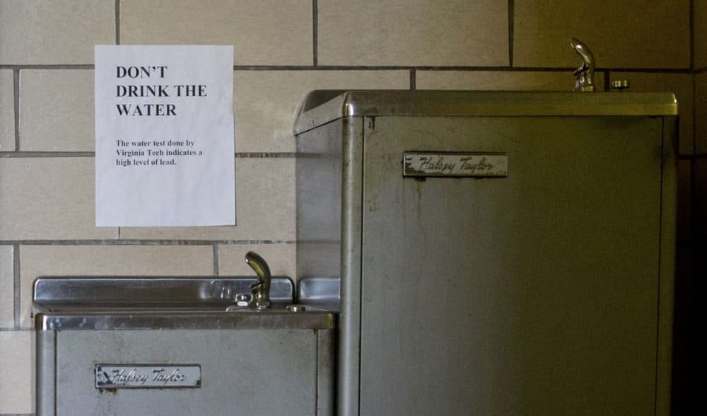 A sign warns people not to drink water contaminated with lead from a fountain in Flint, Mich. But Flint isn't the only place concerned about its water. Four schools in Boston believe a miscommunication may have led to students being exposed to lead-tainted water. (Jacquelyn Martin/AP)