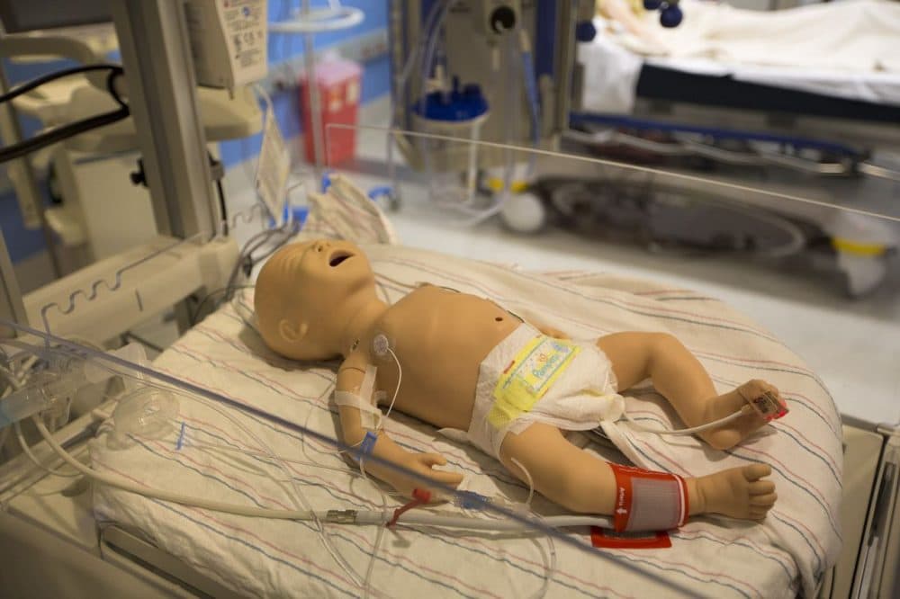 A simulation doll of a very young child lying on a hospital bed in the ICU simulation room. (Jesse Costa/WBUR)
