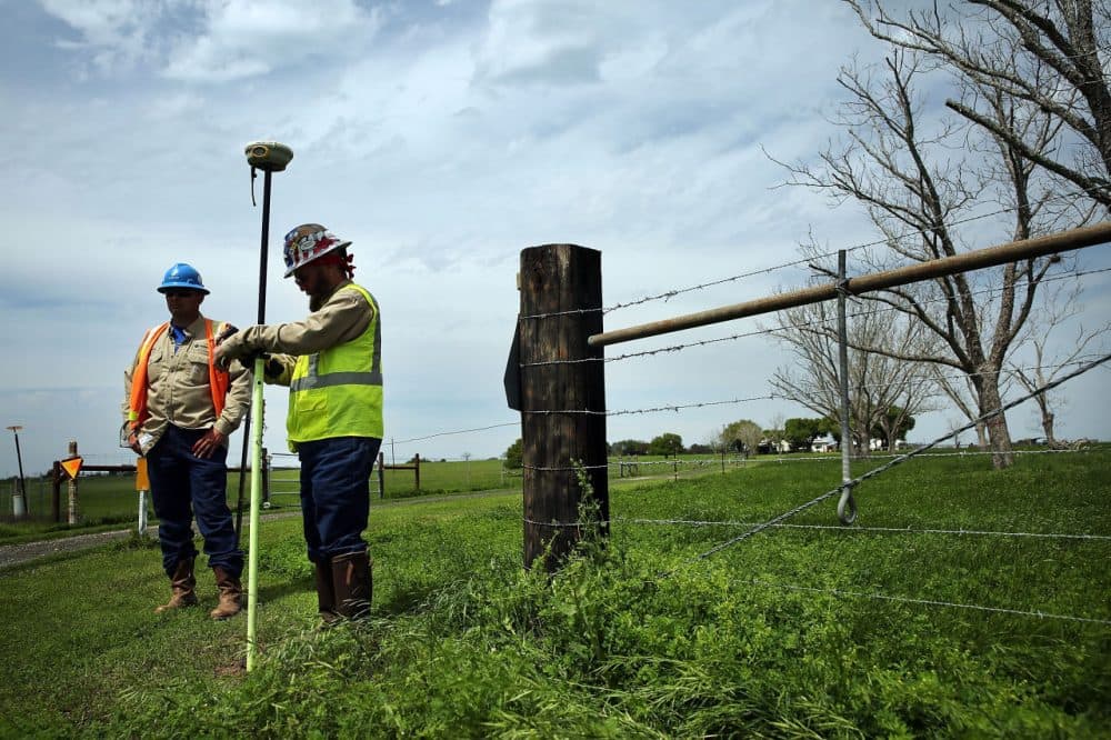 Workers with the oil industry takes GPS coordinates for the laying of new pipe outside of the town of Cuero, Texas. (Spencer Platt/Getty Images)