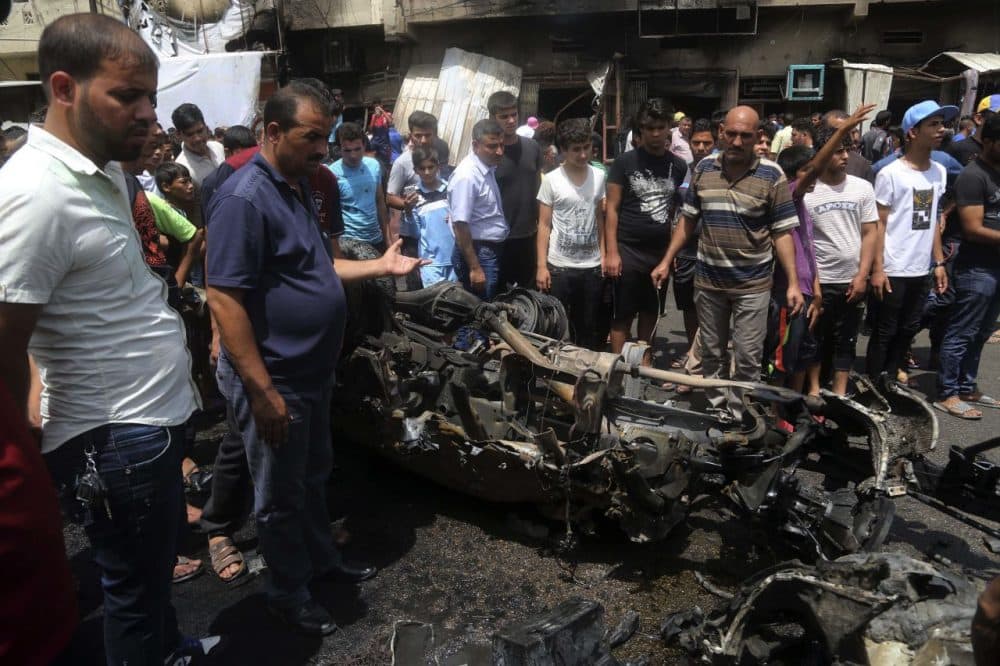 Citizens inspect the scene after a car bomb explosion at a crowded outdoor market in the Iraqi capital's eastern district of Sadr City, Iraq, Wednesday, May 11, 2016. An explosives-laden car bomb ripped through a commercial area in a predominantly Shiite neighborhood of Baghdad on Wednesday, killing and wounding dozens of civilians, a police official said.  (Khalid Mohammed/AP)