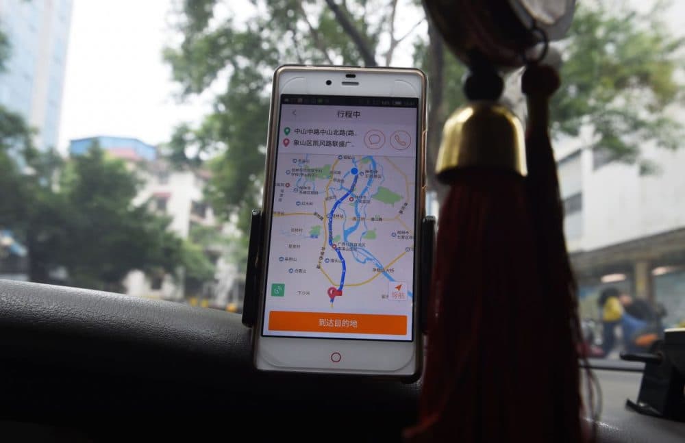 A taxi driver uses the Didi Chuxing app while driving along a street in Guilin, in China's southern Guangxi region on May 13, 2016. (Greg Baker/AFP/Getty Images)