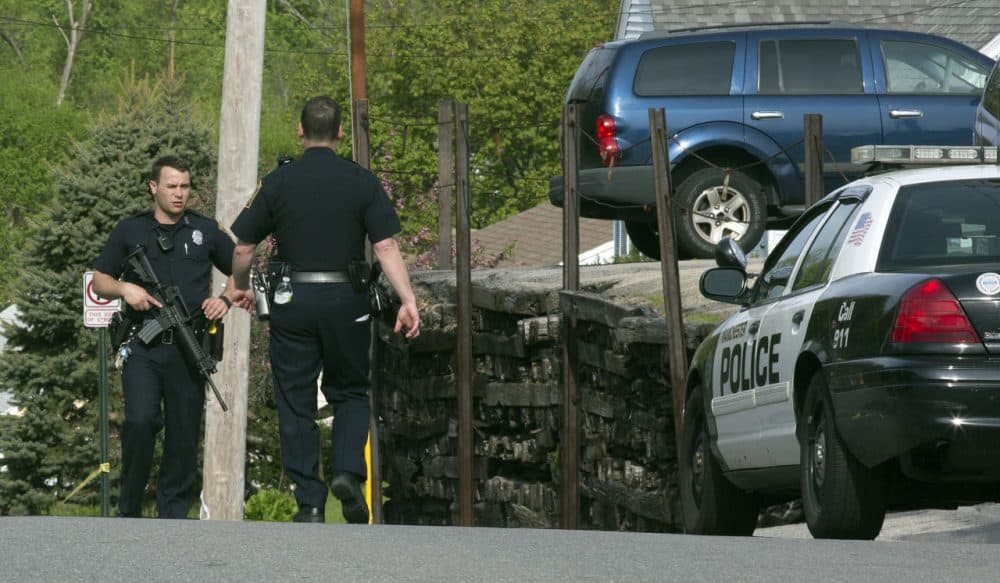 Officers in Manchester, N.H. participate in a search for the suspect in the shootings early Friday. (Jim Cole/AP)
