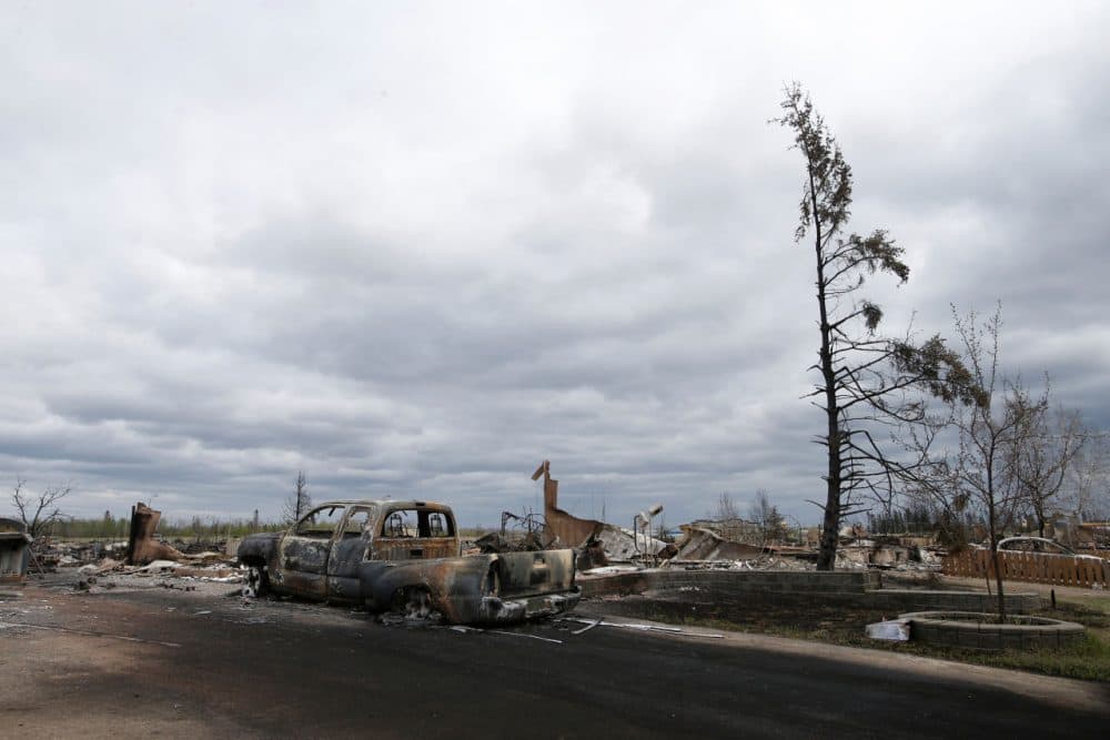 A charred vehicle and homes are pictured in the Beacon Hill neighbourhood of Fort McMurray, Alberta, Canada, May 9, 2016 after wildfires forced the evacuation of the town. Fort McMurray is still 90-percent intact despite a week of damage from the wildfires devastating Canada's oil sands region, Alberta's premier said after touring the deserted city on Monday. Firefighters warned however that the tens of thousands of residents evacuated from the western oil city would not be able to return for at least two weeks. (Chris Wattie/AFP/Getty Images)
