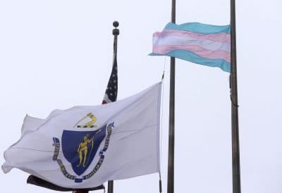 A flag representing the transgender community flies next to the Massachusetts state flag at Boston City Hall. (Steven Senne/AP)