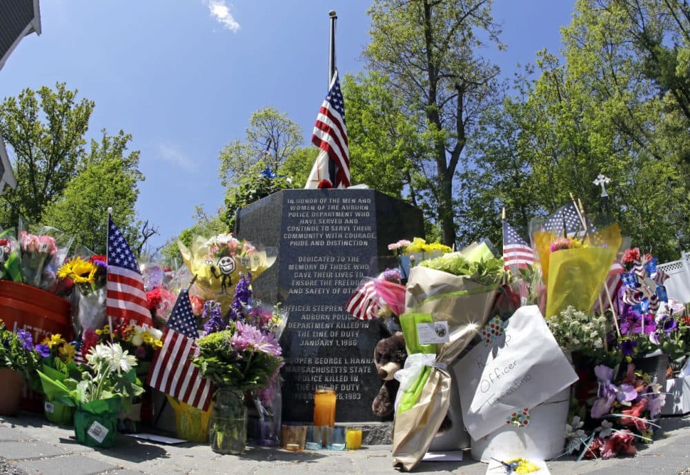 Flowers, flags, and other articles are placed as a memorial for slain Auburn Police Officer Ronald Tarentino outside the police station in Auburn. (Elise Amendola/AP)