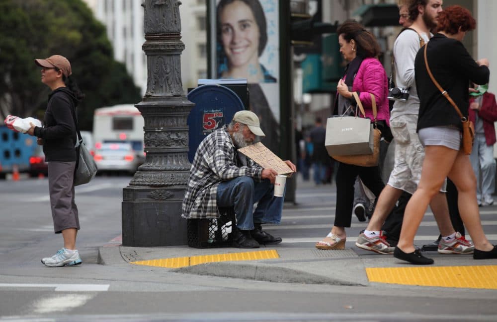 A homeless man holds a sign as he panhandles for spare change on September 16, 2010 in San Francisco, California.