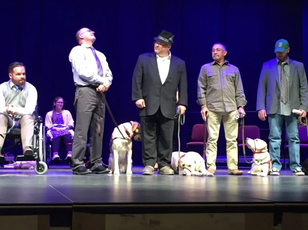 Veterans stand with their NEADS service dogs at the organization's graduation ceremony. (Robin Young/Here &amp; Now)