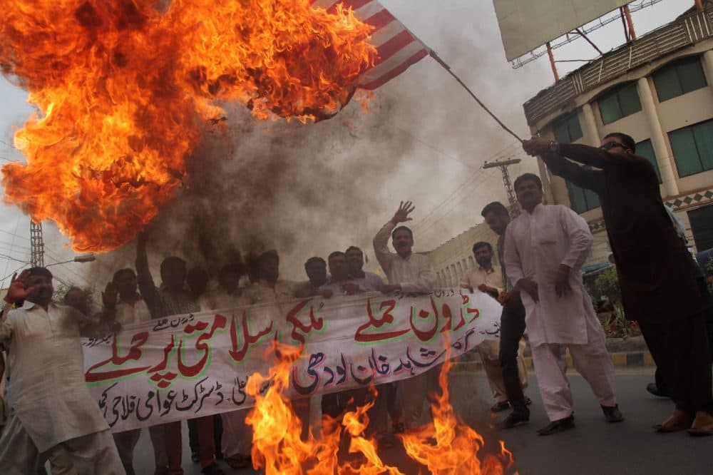 A Pakistani demonstrator holds a burning US flag as others shout slogans during a protest  in Multan on May 24, 2016, against a US drone strike in Pakistan's southwestern province Balochistan. (SS Mirza/AFP/Getty Images)