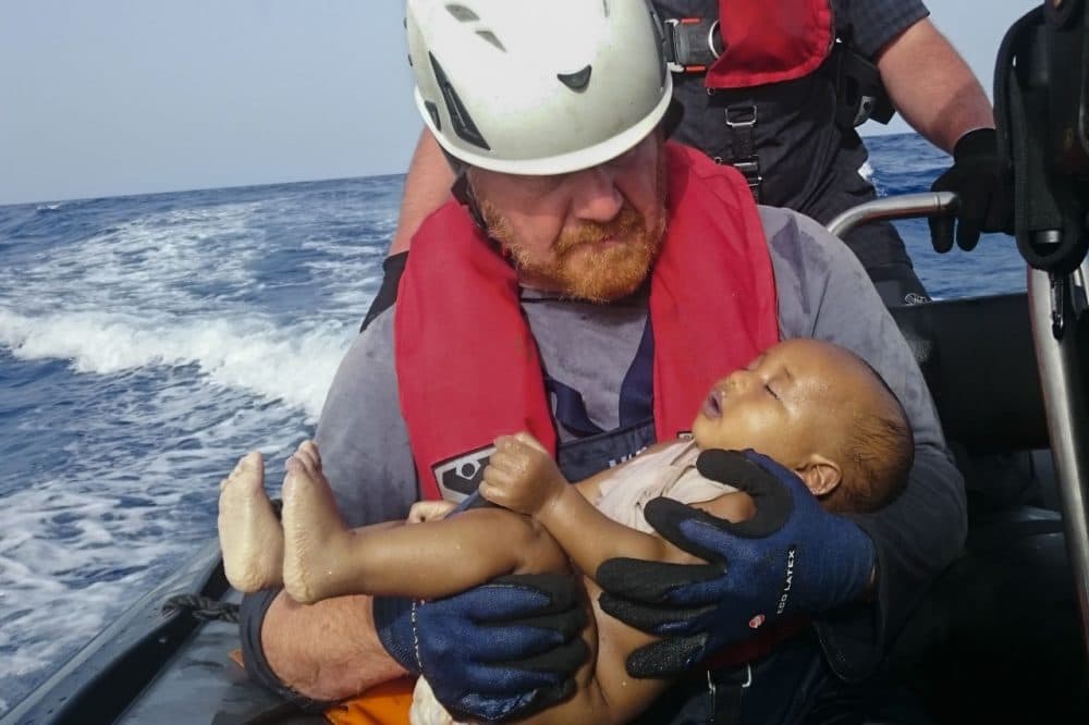 In this Friday, May 27, 2016 photo, a Sea-Watch humanitarian organization crew member holds a drowned migrant baby, during a rescue operation off the coasts of Libya. (Christian Buttner/EIKON NORD GMBH GERMANY via AP)